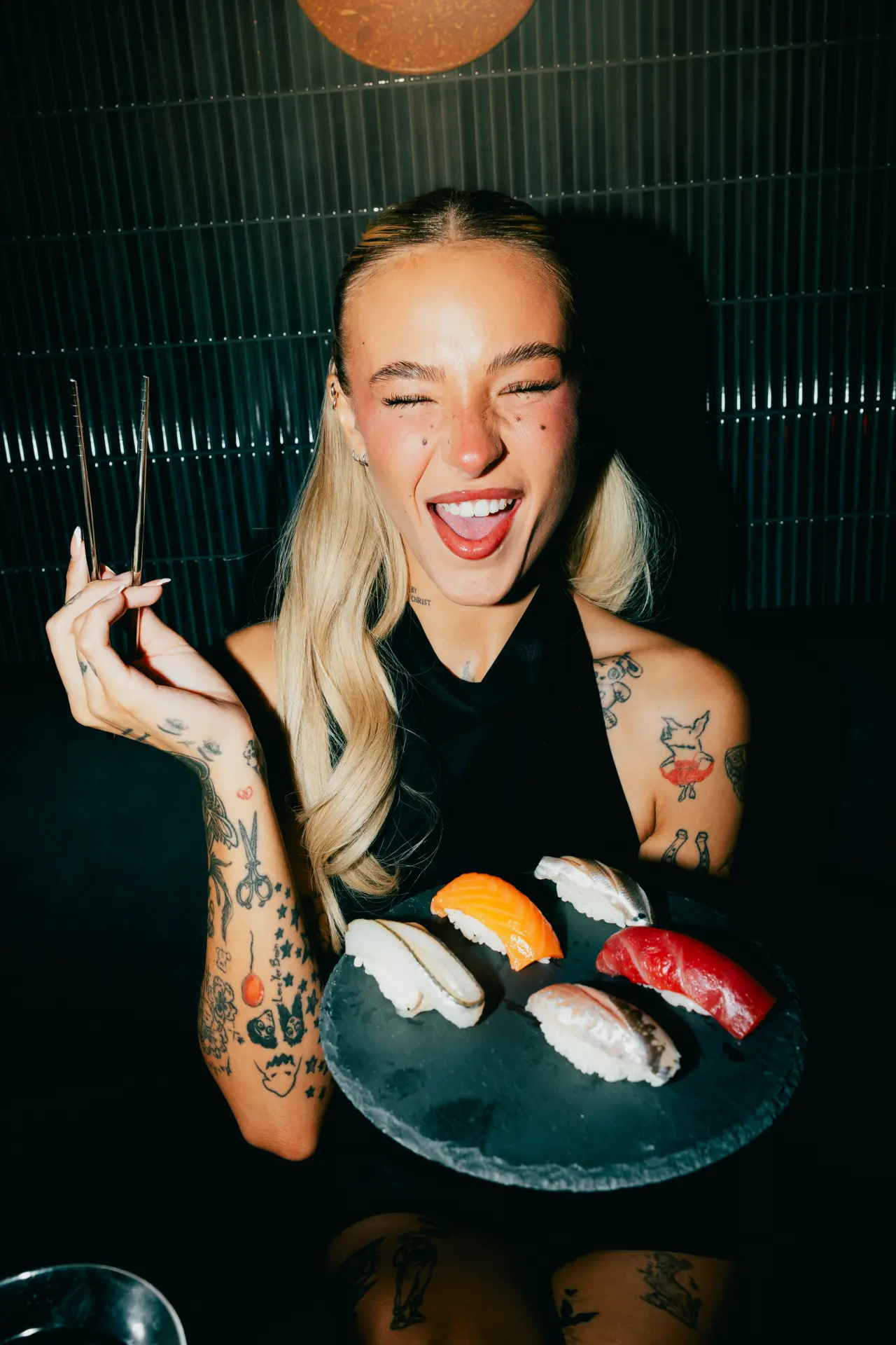 A guest laughing with a plate of nigiri