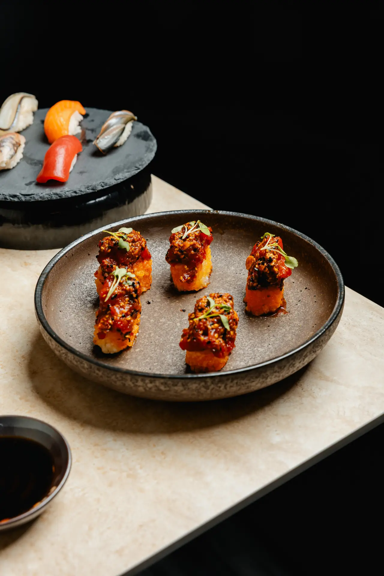 Sushi rolls on a dark plate at KUZA